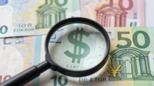 Forex currency symbols with a magnifying glass.